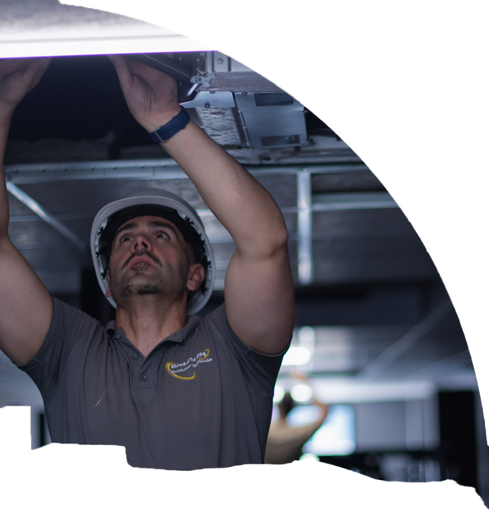 Técnico de Electricas DPS realizando mantenimiento de climatización en techo de local comercial en Alcantarilla, Murcia